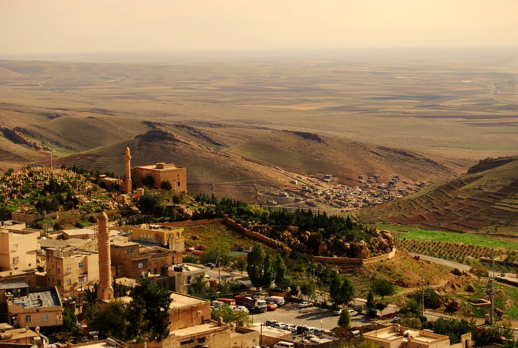 Vast, fertile plains of Mesopotamia with fields of wheat and distant mountains